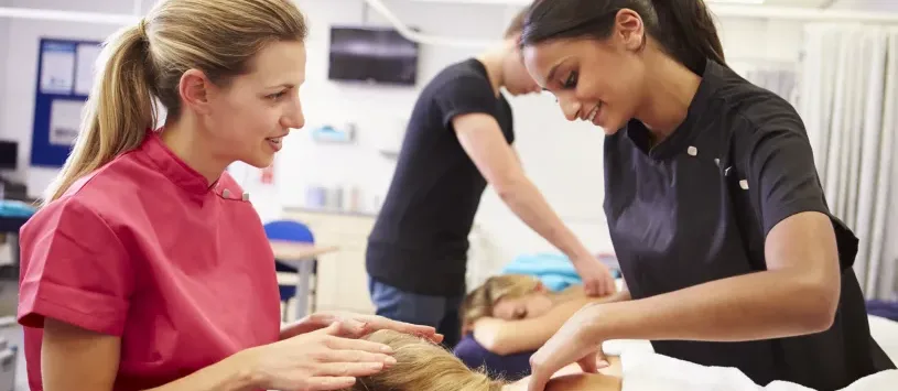 Teacher Helping Student Training To Become Masseuse
